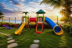 a playground with a slide on the grass near the beach at Pousada Boa Sorte in Cumuruxatiba