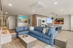 a living room with a blue couch and a kitchen at VCAY Hotel 5BR 5BA Group Suite Near Superdome in New Orleans