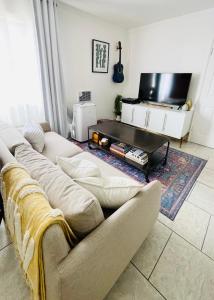 a living room with a couch and a flat screen tv at Downtown Studio Free Parking 1 mi to Beach & Convention Center in Long Beach