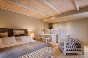 a bedroom with a bed and a chair and a kitchen at Melitsina Village Hotel in Kardamyli +62 photos