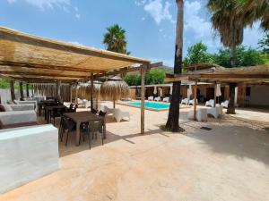 a patio with tables and chairs and a pool at Fuente del Lobo Glamping & Bungalows - Adults Only in Pinos Genil