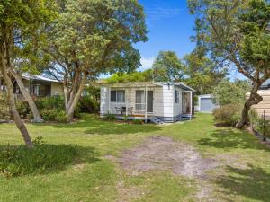 a small white house with trees in the yard at Prom Coast - Seabreeze in Sandy Point