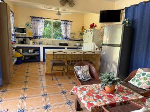 a kitchen with a refrigerator and a table in it at YETHAN HOUSE in Uvita