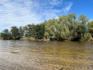 a body of water with trees in the background at La Casona Dique Chico in Villa Anizacate