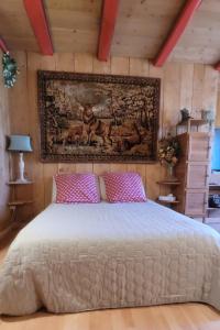 a bedroom with a large white bed with pink pillows at le relais de l'abelan in Blesle