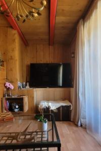 a living room with a flat screen tv and a table at le relais de l'abelan in Blesle