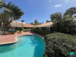 a swimming pool in front of a house at Blue Marlin Apartments, nabij Mambo Beach in Willemstad