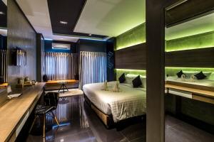 武里南Cresco Hotel Buriram的一间带床和书桌的酒店房间