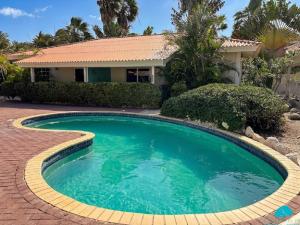 a swimming pool in front of a house at Blue Marlin Apartments, nabij Mambo Beach in Willemstad +30 photos
