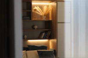 a room with a book shelf with two chairs and a refrigerator at Bed & Breakfast Oasi San Giovanni in Altamura