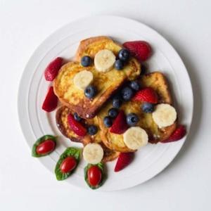 a plate with french toast with fruit and bananas at Charlotte Garden Bed and Breakfast in Niagara-on-the-Lake