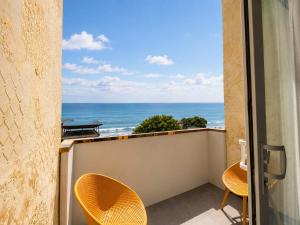 a balcony with chairs and a view of the ocean at The Marina Palace Calicut Premium Beach Hotel in Kozhikode
