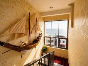a large wooden boat hanging on a wall in a room at The Marina Palace Calicut Premium Beach Hotel in Kozhikode