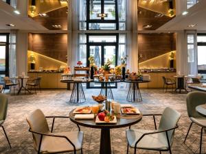 a hotel lobby with tables with food on them at Le Louis Hotel Versailles Château - MGallery Collection in Versailles