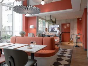 a restaurant with red walls and a table and chairs at ibis Rueil-Malmaison Centre in Rueil-Malmaison