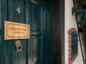 a green door with a sign on it at Pokój dyrektora stadniny in Niezgoda