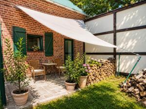 a patio with plants and a table with a white awning at Pokój dyrektora stadniny in Niezgoda