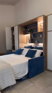 a bedroom with a large white bed with blue pillows at Bed & Breakfast Oasi San Giovanni in Altamura