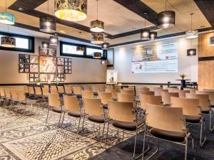 a conference room with chairs and a projection screen at Novotel Paris 14 Porte d'Orléans in Paris