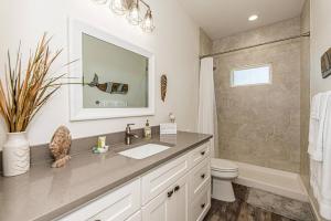 a bathroom with a sink and a toilet and a mirror at Mills Fishing Cabin in Port Aransas +80 photos