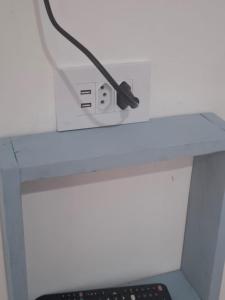 a black cord plugged into an electrical outlet on a desk at Nova Perola de Guaruja in Guarujá