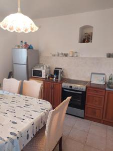 a kitchen with a table and a stove top oven at Holiday Home Tomislav in Komiža