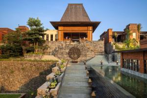 a building with a pool in front of it at Garrya Bianti Yogyakarta in Yogyakarta
