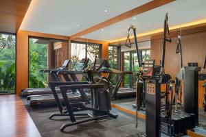 a gym with several treadmills and elliptical machines at Garrya Bianti Yogyakarta in Yogyakarta