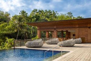 a resort with a swimming pool and lounge chairs at Garrya Bianti Yogyakarta in Yogyakarta