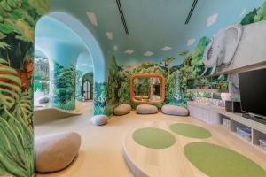 a childrens play room with a dinosaur mural on the wall at Mandai Rainforest Resort by Banyan Tree in Singapore