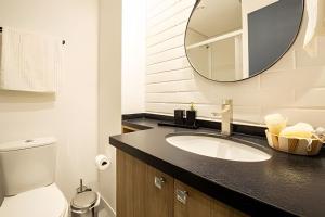 a bathroom with a sink and a mirror at Loft 406 Inn - Parque Una + garagem in Pelotas +22 photos