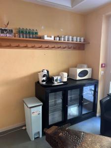 a small black table with a microwave on it at Auberge des Veillees in Blesle