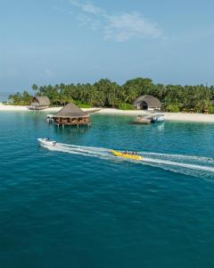 a boat in the water next to an island at Angsana Velavaru - part of Banyan Group with Free return Seaplane Transfers in Dhaalu Atoll +189 photos