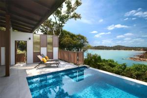 a swimming pool with a view of the water at Garrya Tongsai Bay Samui in Choeng Mon Beach