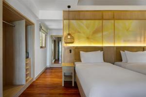 a bedroom with two beds and a closet at Garrya Tongsai Bay Samui in Choeng Mon Beach