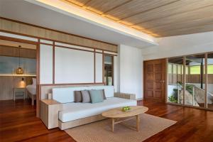 a living room with a white couch and a table at Garrya Tongsai Bay Samui in Choeng Mon Beach