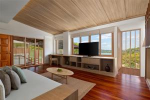 a living room with a couch and a flat screen tv at Garrya Tongsai Bay Samui in Choeng Mon Beach