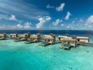 an aerial view of overwater bungalows in the ocean at Angsana Velavaru - part of Banyan Group with Free return Seaplane Transfers in Dhaalu Atoll