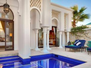 a villa with a swimming pool and a house at Banyan Tree Tamouda Bay in Fnidek