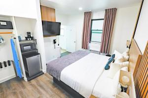 a hotel room with a bed and a flat screen tv at Urban Boutique Hotel- Little Italy, Downtown San Diego in San Diego