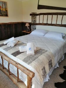 a large bed with white sheets and towels on it at Estancia Dos Elianas in Cerro Castillo