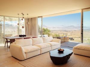 a living room with a white couch and a table at Banyan Tree Veya, Valle de Guadalupe in Valle de Guadalupe