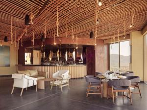 a restaurant with tables and chairs and a bar at Banyan Tree Veya, Valle de Guadalupe in Valle de Guadalupe