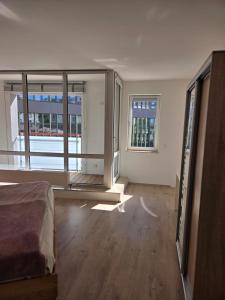an empty room with a bed and large windows at Brenz City Stay in Heidenheim an der Brenz