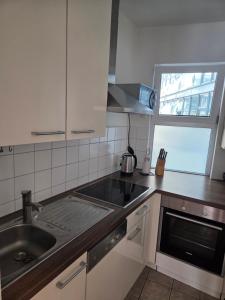 a kitchen with a sink and a stove and a window at Brenz City Stay in Heidenheim an der Brenz