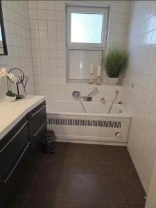 a white bathroom with a tub and a window at Brenz City Stay in Heidenheim an der Brenz +10 photos