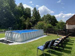 a swimming pool in the grass with chairs around it at Na Uboczu in Gryfów Śląski +59 photos