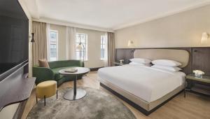 a bedroom with a large white bed and a green couch at Hyatt Regency London Blackfriars in London +95 photos