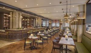 a restaurant with tables and chairs and a bar at Hyatt Regency London Blackfriars in London