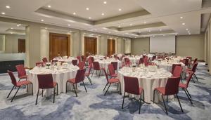 a conference room with white tables and red chairs at Hyatt Regency London Blackfriars in London